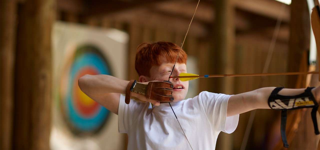 Boy aiming a bow in Target Archery