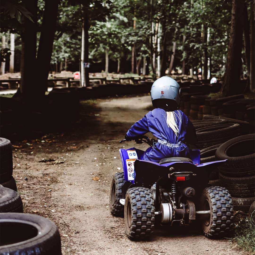 Young boy riding a Quad Bike through the forest