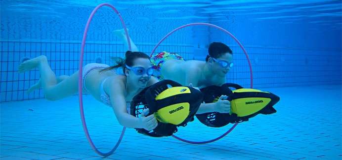 Two young people swimming under the water in Aqua Jetting