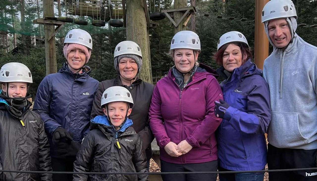 Family posing in their helmets ready to tackle the Aerial Adventure course.