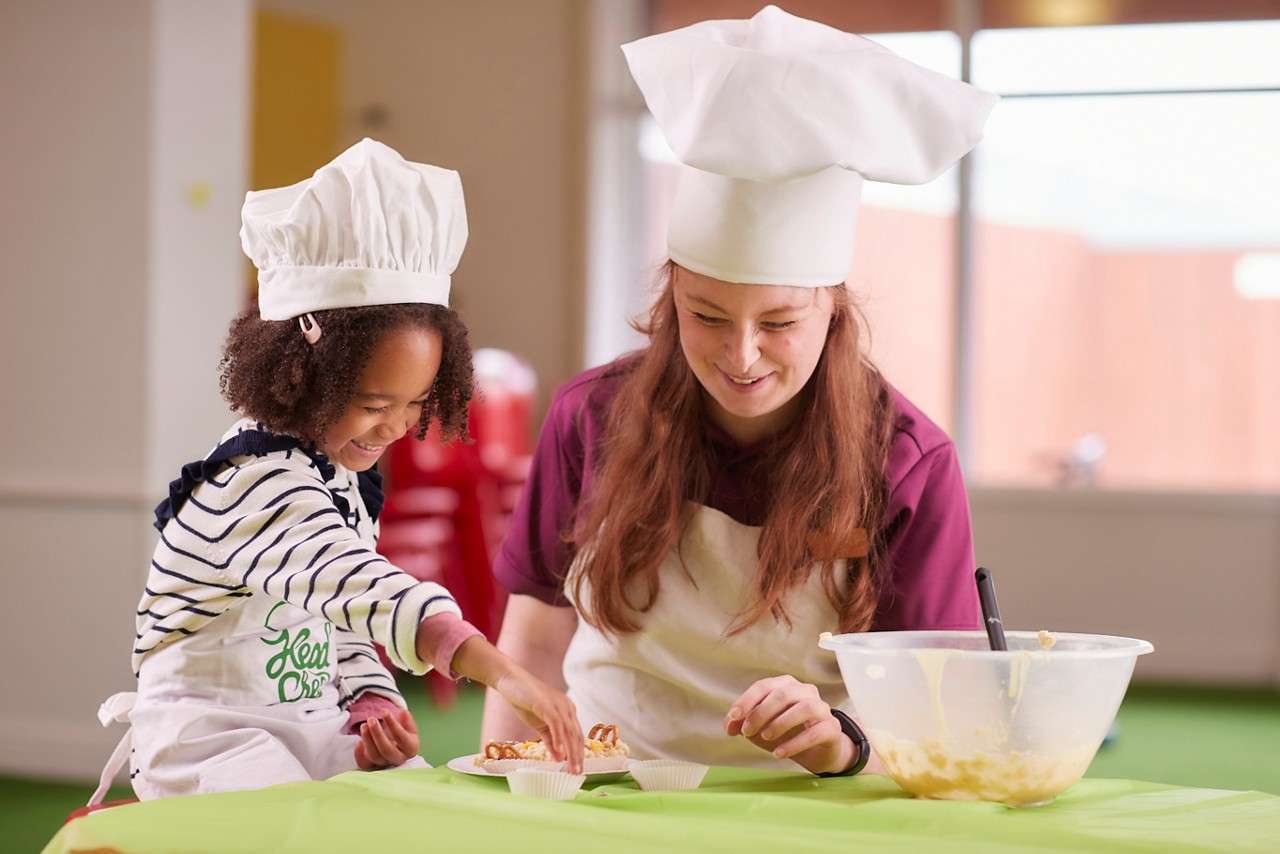 Young person dressed as a chef, making chocolate treats.