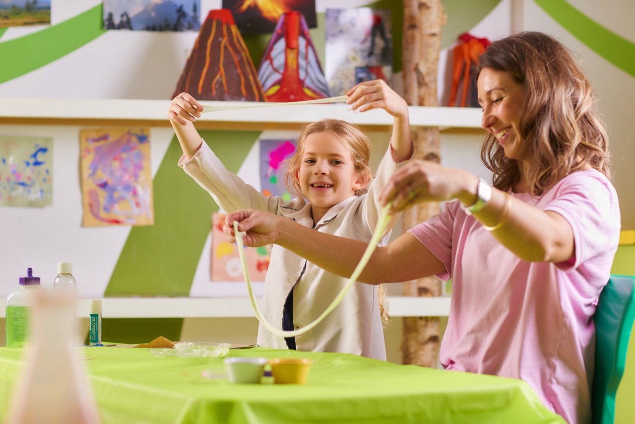 Young person and an adult playing with slime.