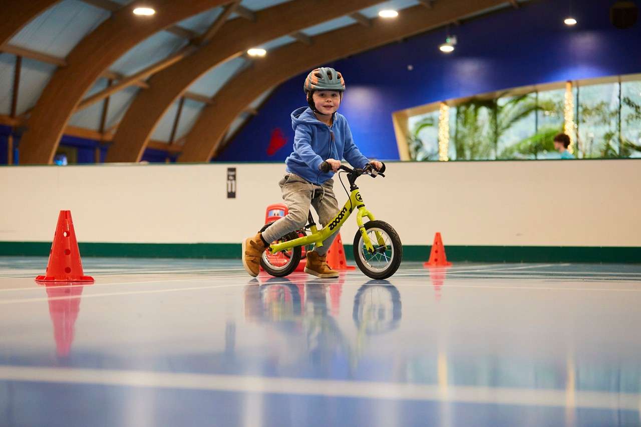 Young boy wearing a helmet practicing his skills on a balance bike.