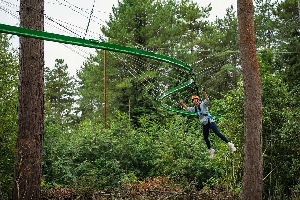 Woman flying through the trees on the Treetop Glider.