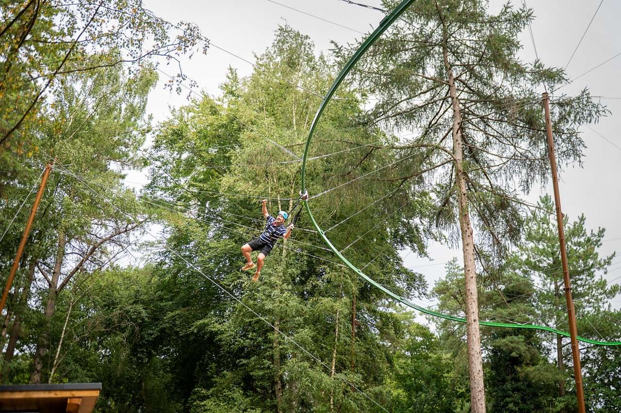 Man gliding across a suspended metal track.