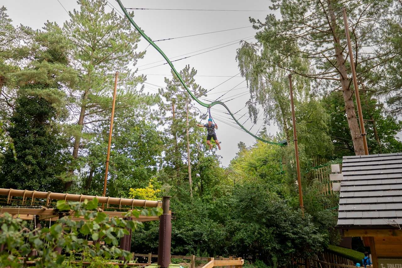Man gliding across a suspended metal track.