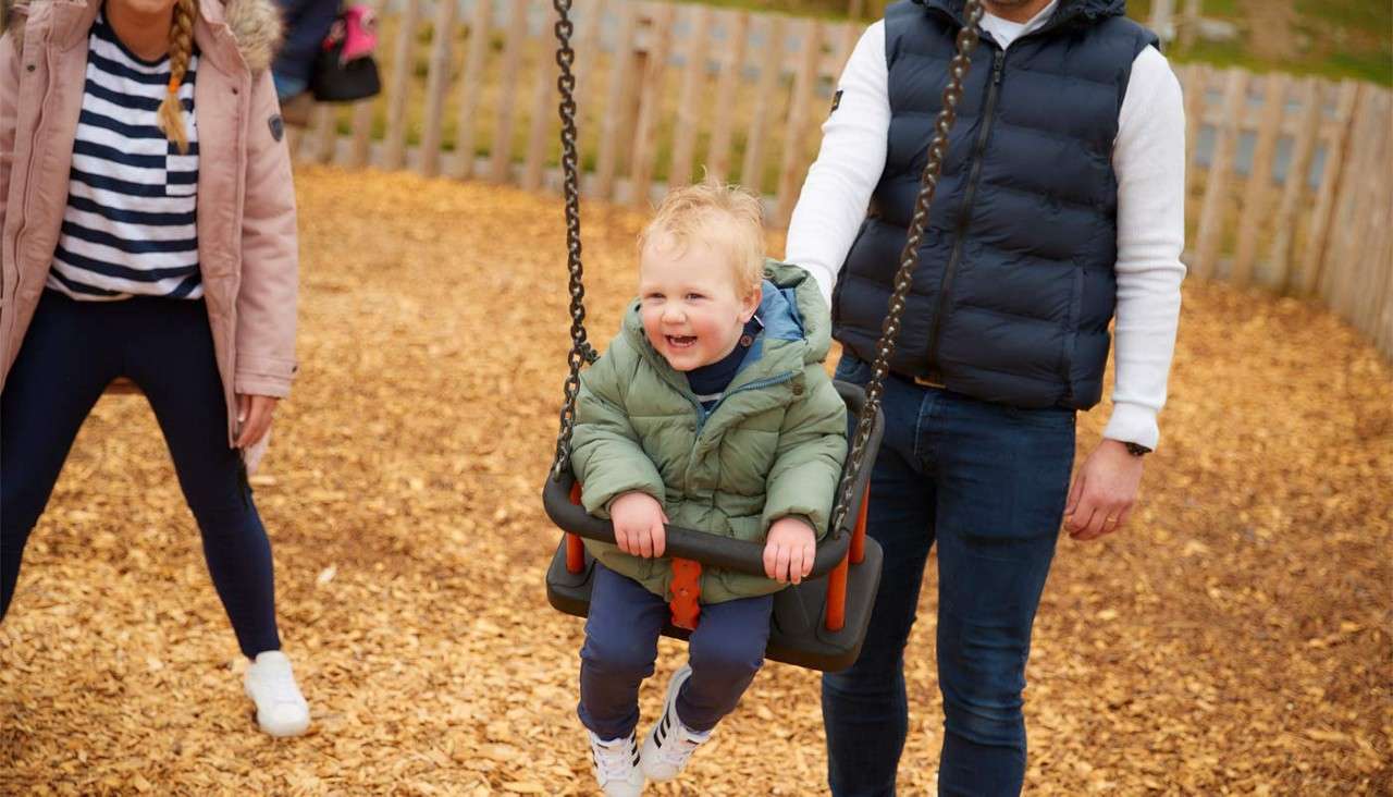 Young boy in a swing on an outdoor play area