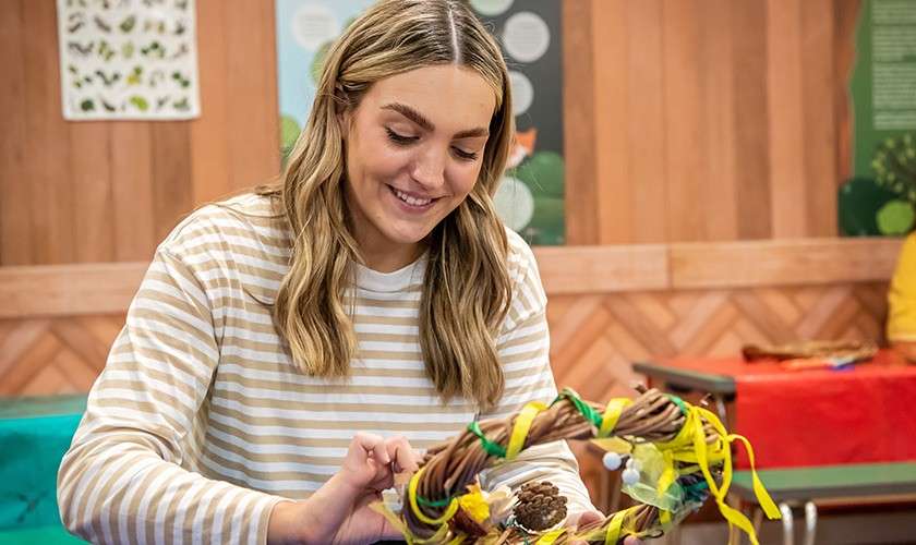 A woman making an Easter wreath during the Easter Willow Wreath Making.