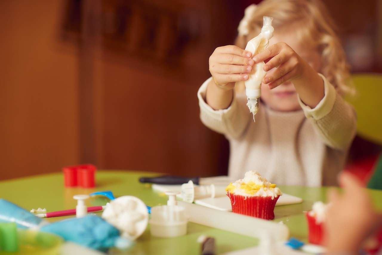 Young girl decorating cupcakes.