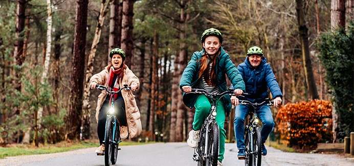 Family cycling through the forest.