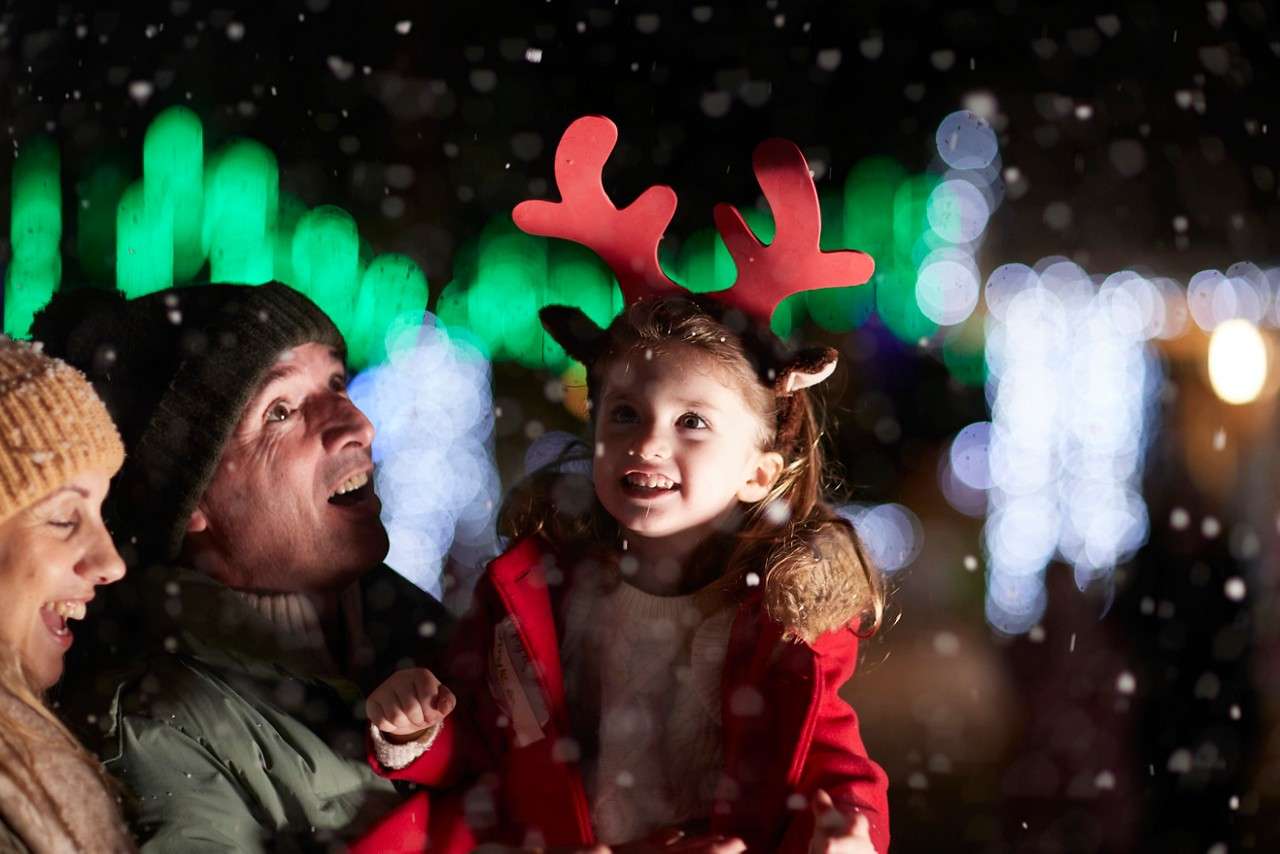 Young girl standing in a shower of fake snow.