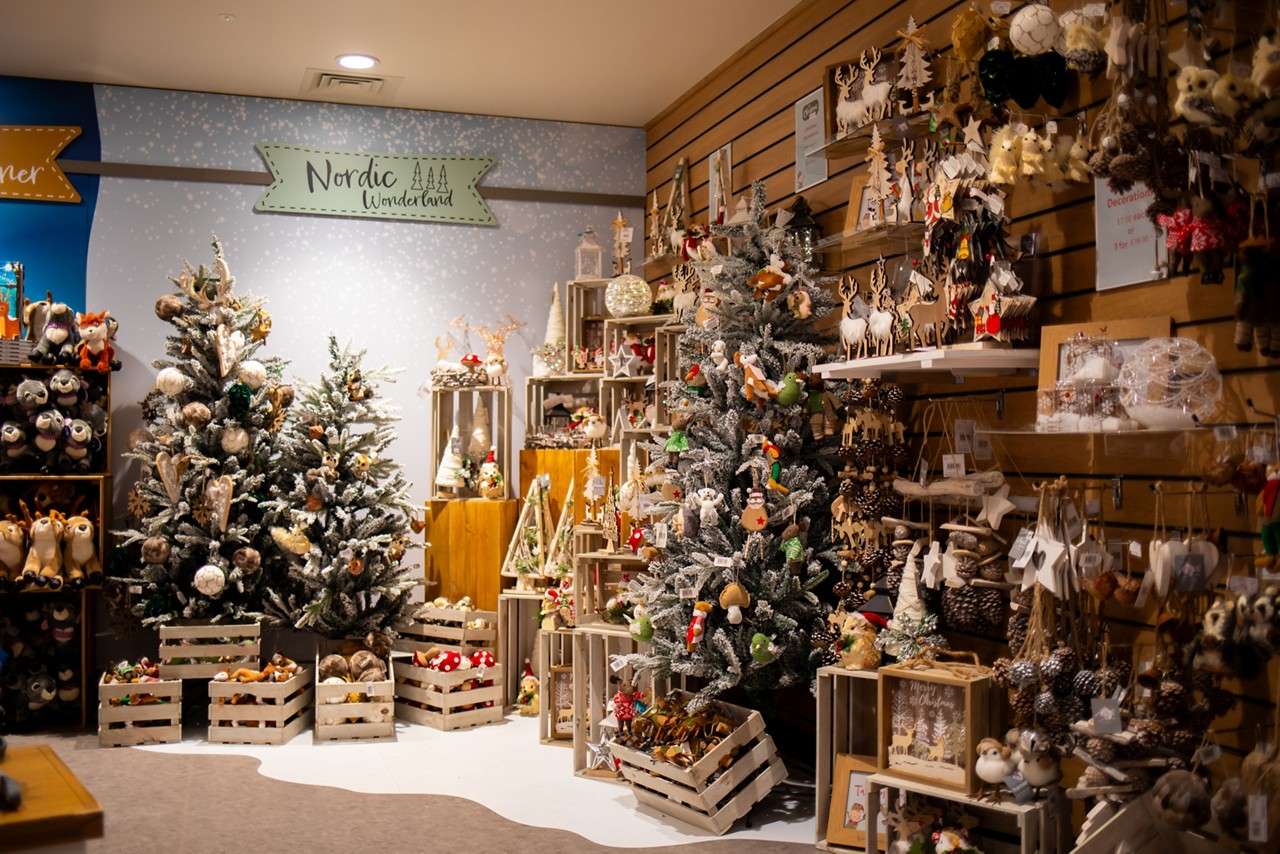 A shop stocked with festive items, like baubles, Christmas Trees and ornaments.
