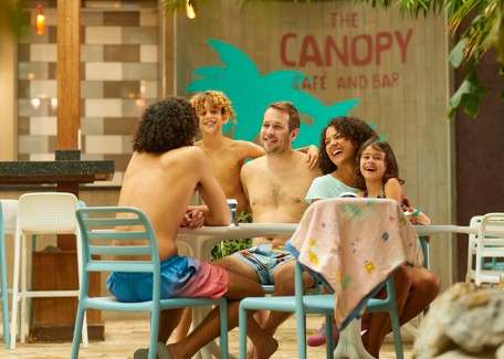 A family sat round a table at the Canopy Cafe laughing. 