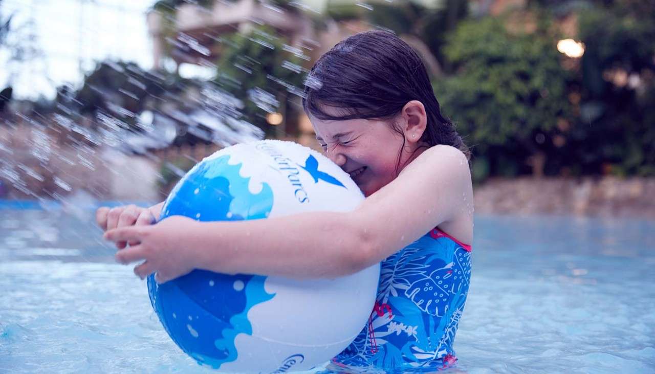 Girl with beach ball in pool