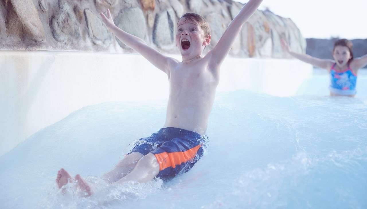 A child sliding down the rapids of the Subtropical Swimming Paradise