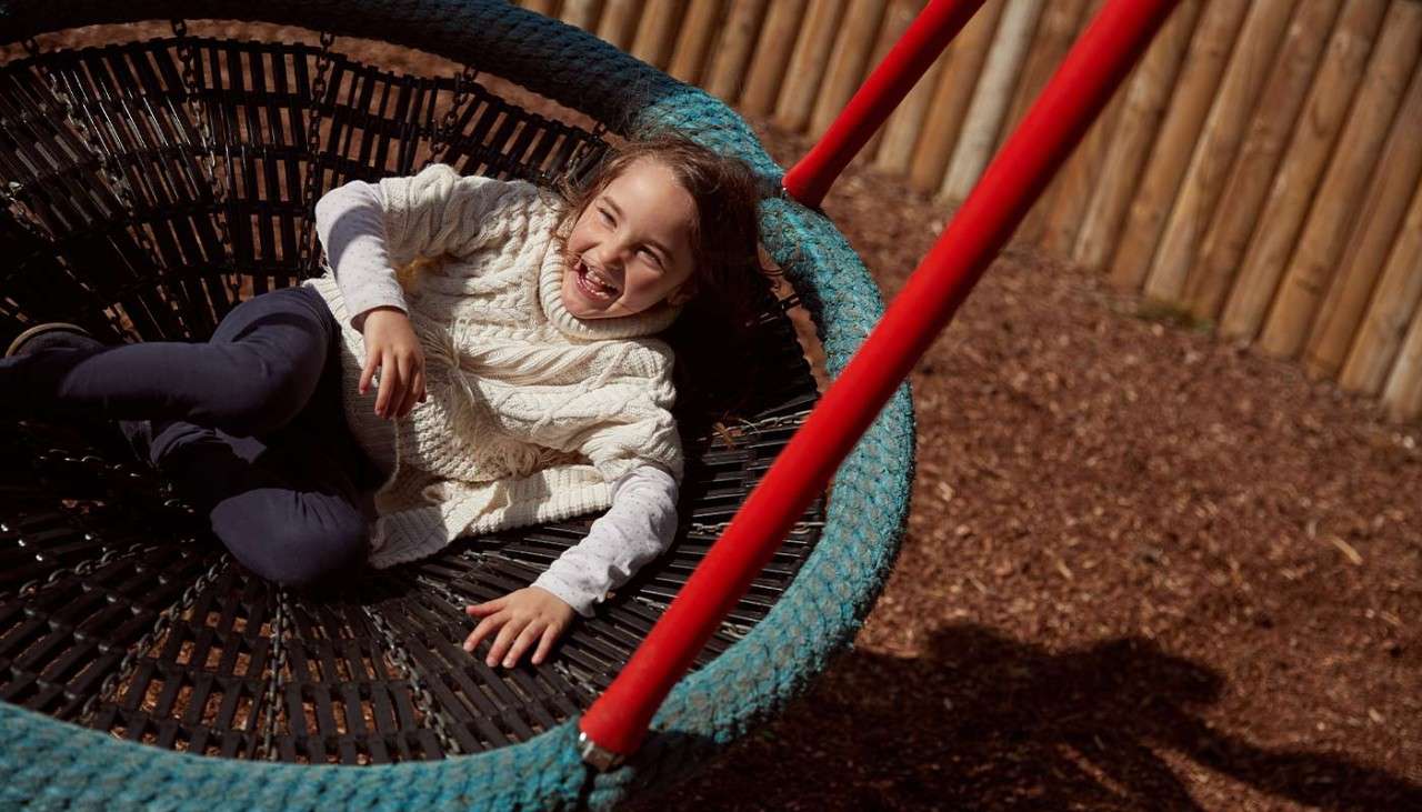 A child on a swing in an outdoor playground