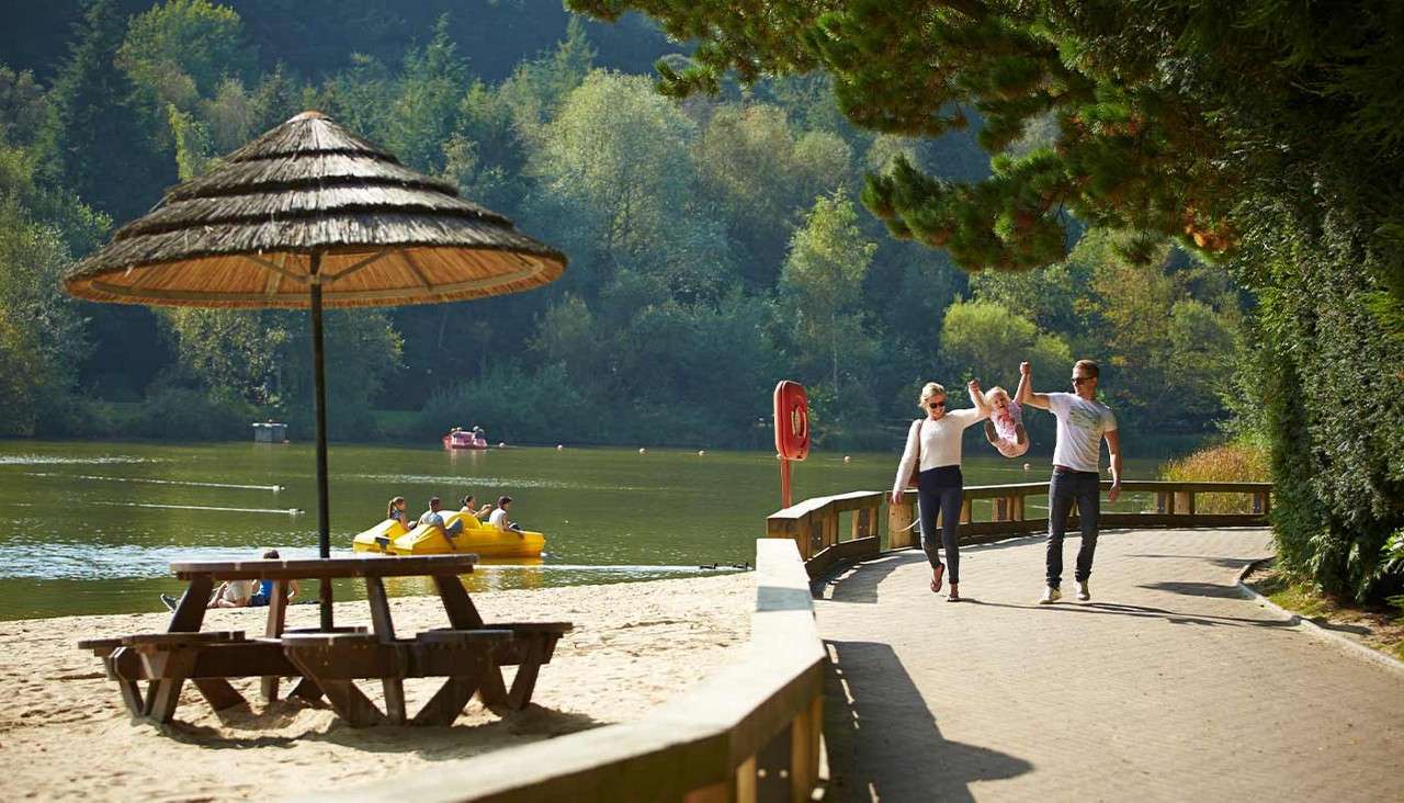 A family walking by the lake holding hands