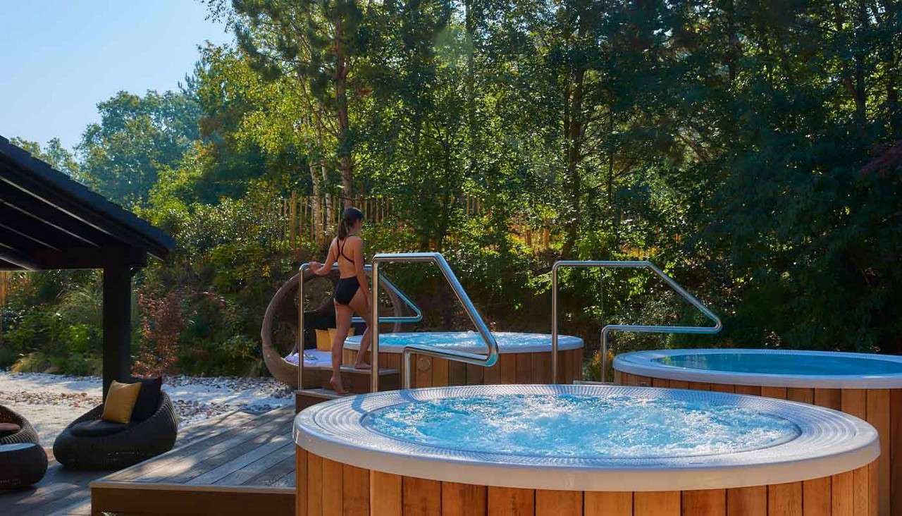 Woman stepping into an outdoor hot tub.