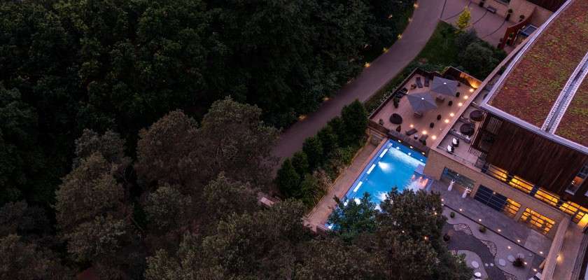 Aerial shot of an outdoor pool surrounded by woodland