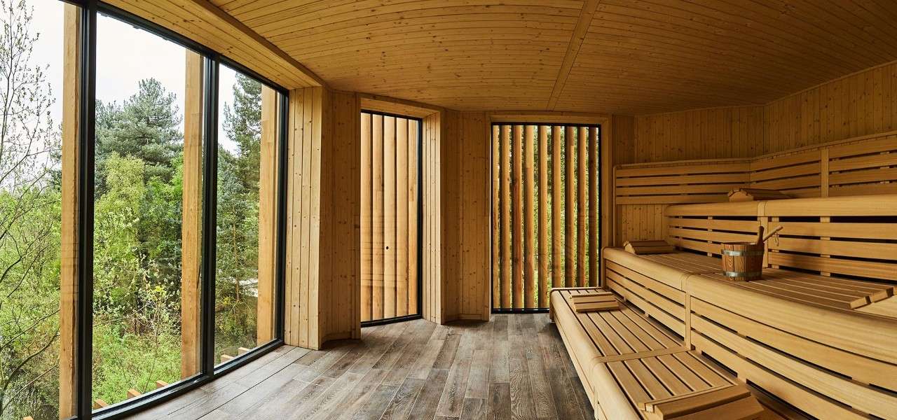 Wooden Nordic sauna looking out into the woodland scenery. 