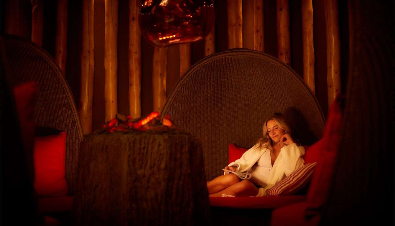 Woman sitting reading a book in the Fireside Relax