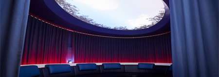 Oval room with comfortable chairs and a glass dome on the ceiling to observe the sky lined with tree branches.