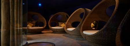 Comfortable egg chairs in a dim lit room.