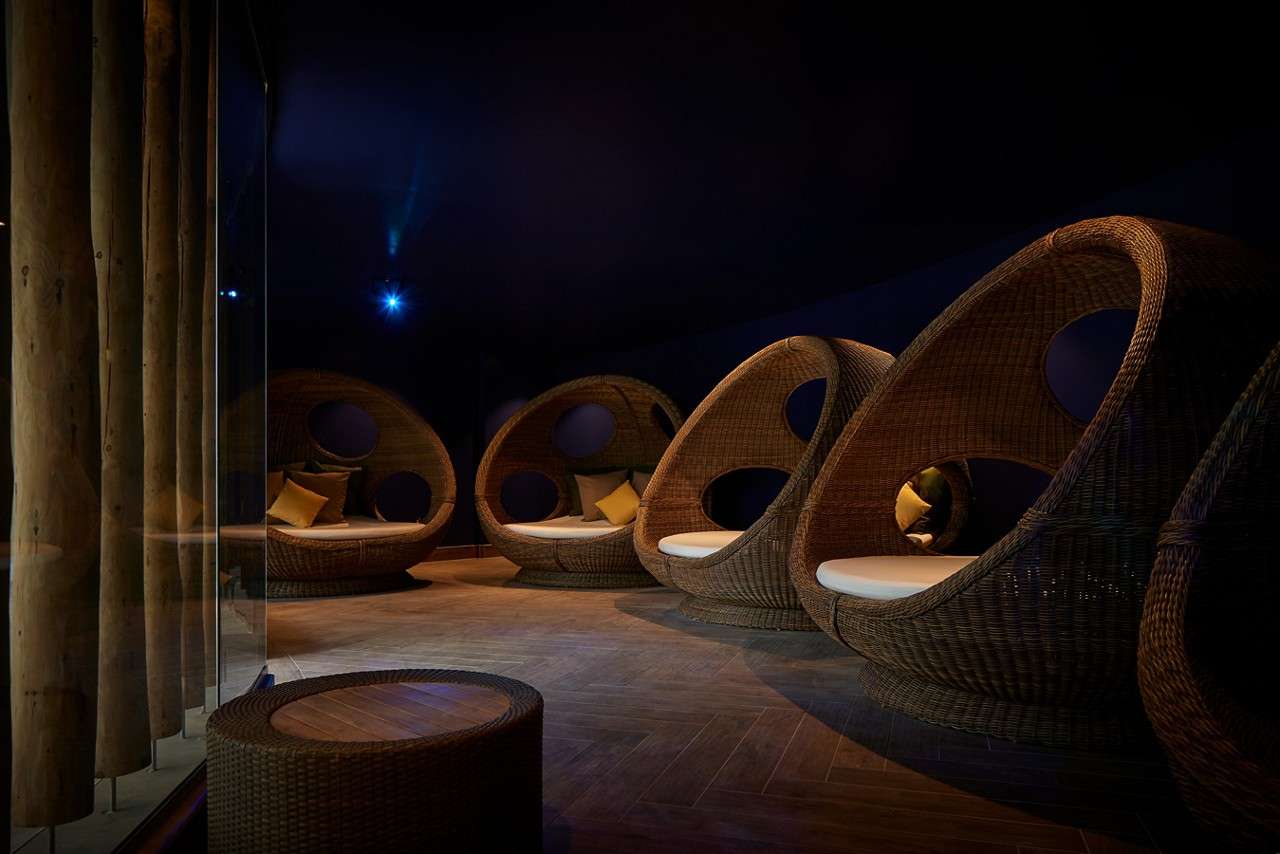 Comfortable egg chairs in a room with dim lighting.
