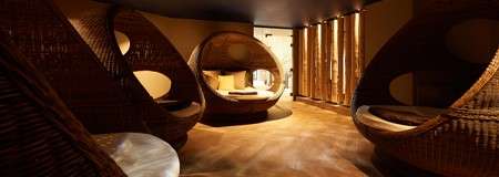 Comfortable egg chairs in a dim lit room.