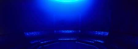 Inside of a dark circular room lined with seating.