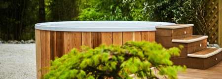 Hot tub with steps and decorative plants.