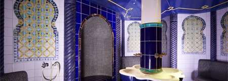 Tiled room with a central basin with multiple taps.