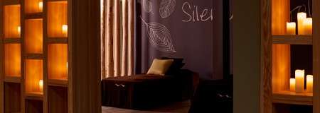 Waterbeds in a room lit with glowing candles.