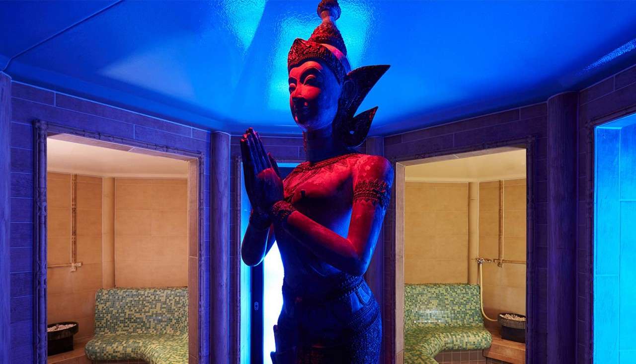 Whinfell Forest Balinese Steam rooms with a large statue glowing in relaxing light.