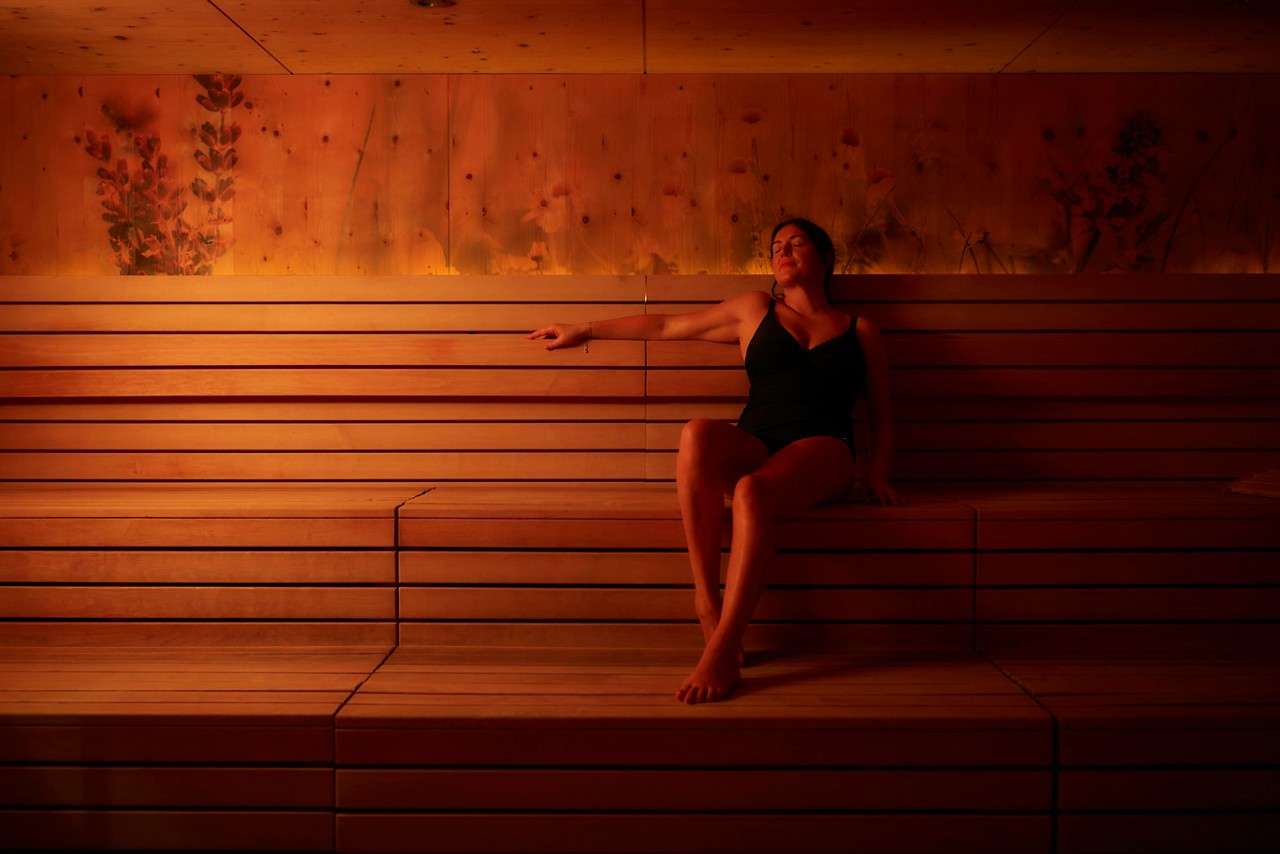 Woman sat on a wooden bench in the Herbal Sauna.