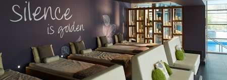 Multiple waterbeds with throw pillows in a room decorated with candles.