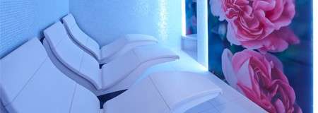 Luxury contoured loungers in a room with a floral wall.  