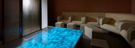 Arm chairs lining a room with waves projected on the floor.