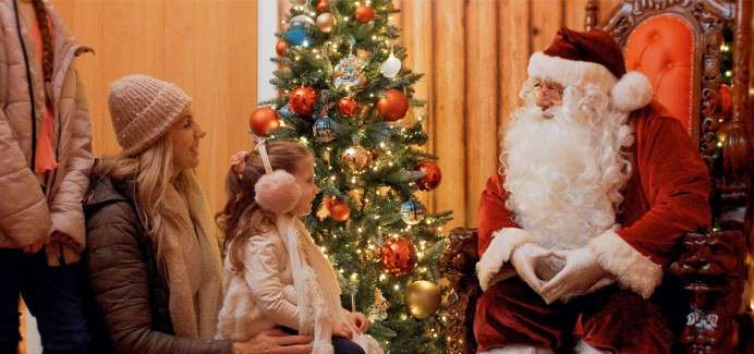 Young girl talking with Santa in his Grotto.