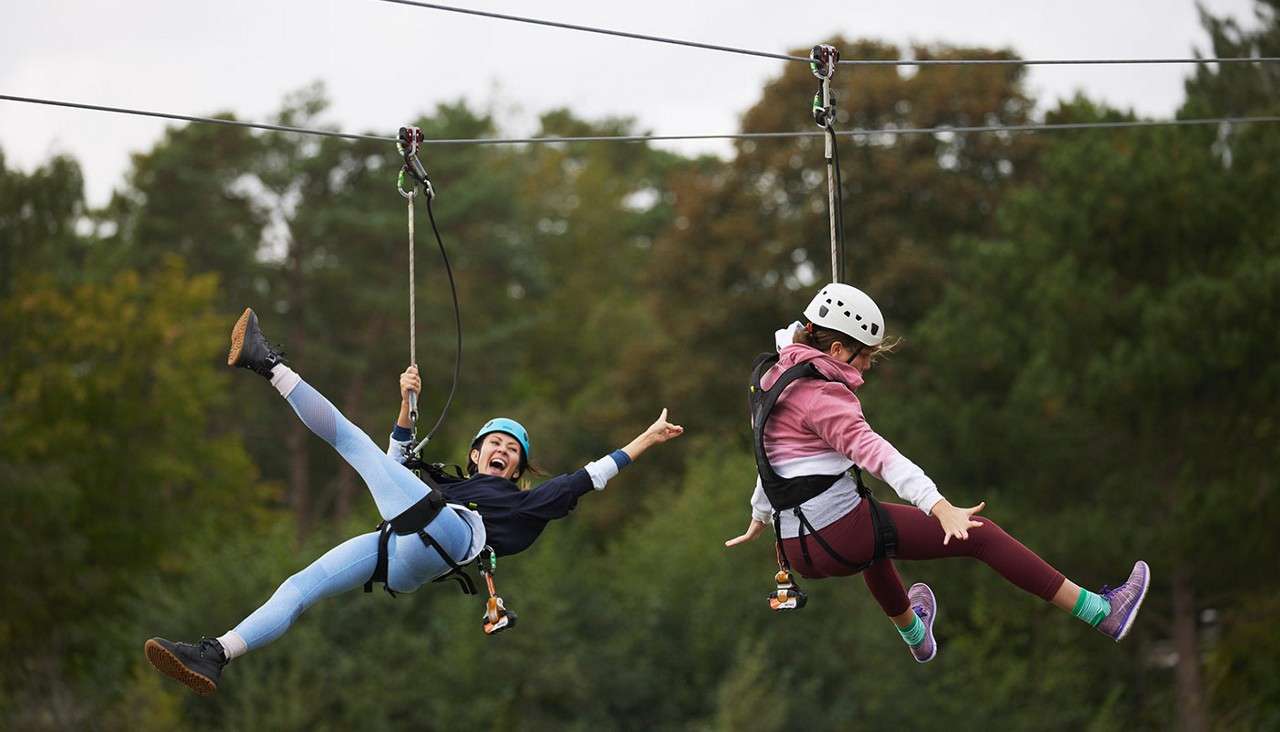 People on the zip wire going over the lake.