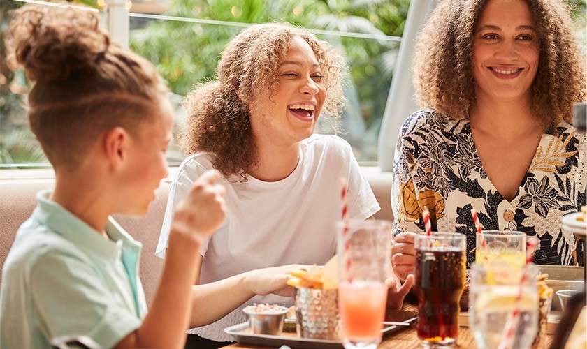 A family laughing whilst eating a meal at Hucks Restaurant.