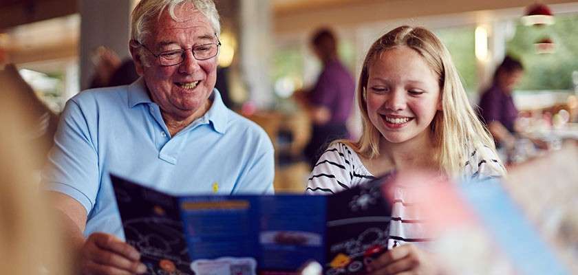 Older man and teenage girl looking at a menu