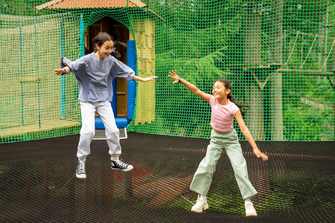 Two children jumping together in the Adventure Nets.