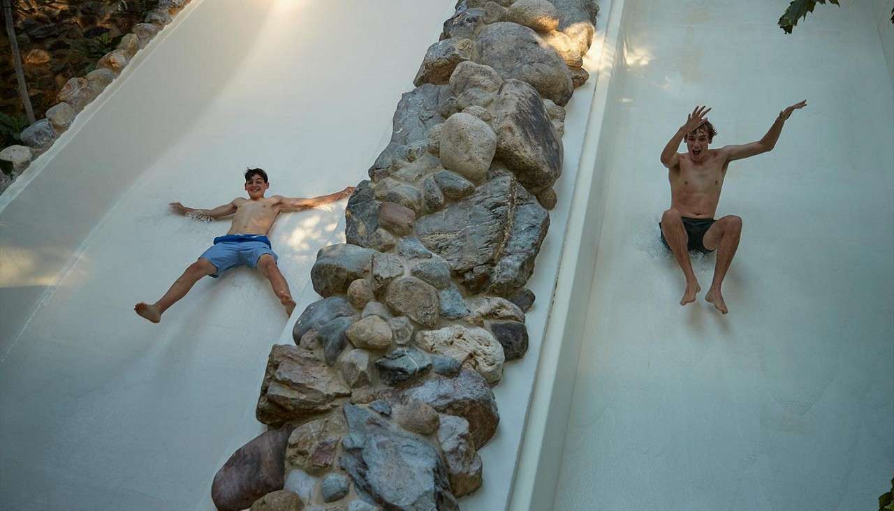 Two boys going down waterslides