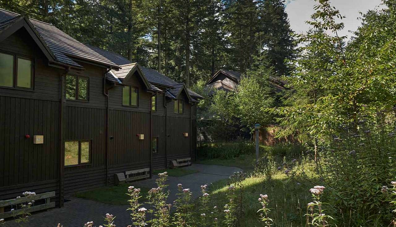 The outside of a lodge in a forest 
