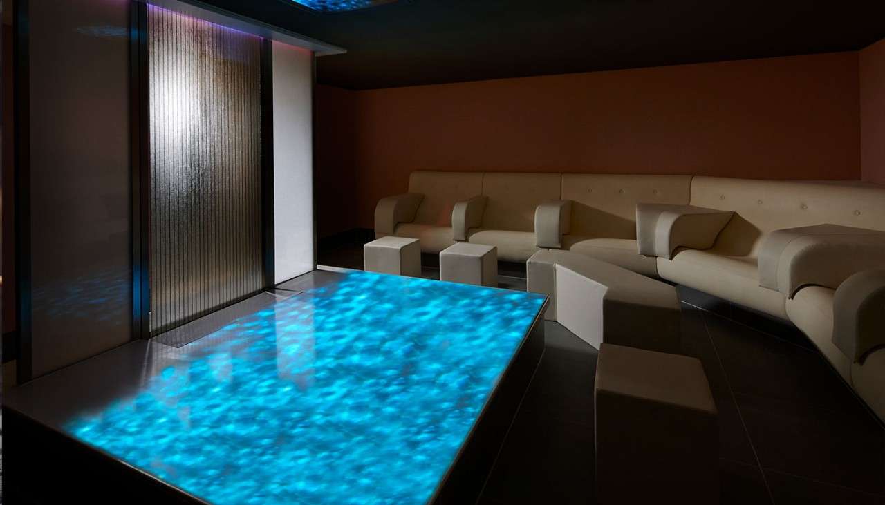 A dark and serene room with chairs, The Relaxation Room at Aqua Sana Spa.