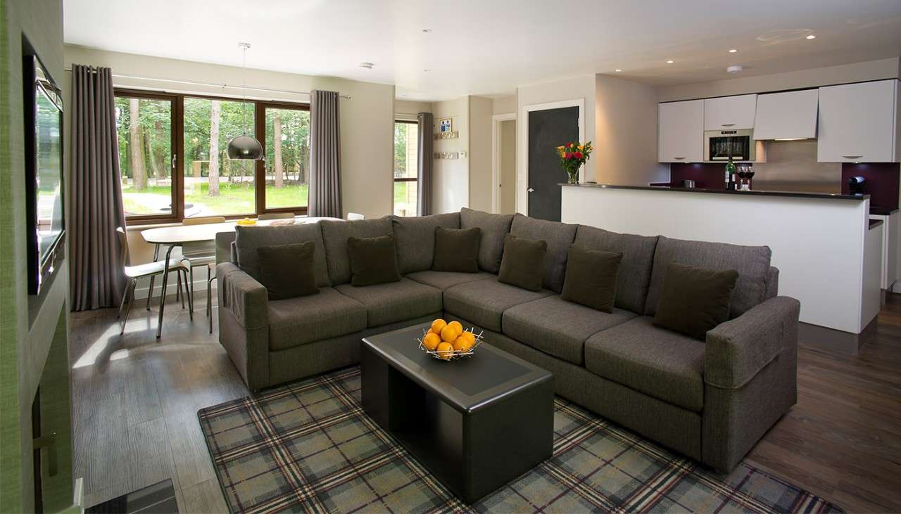The lounge of an Executive lodges with a corner sofa and coffee table with big windows in the background