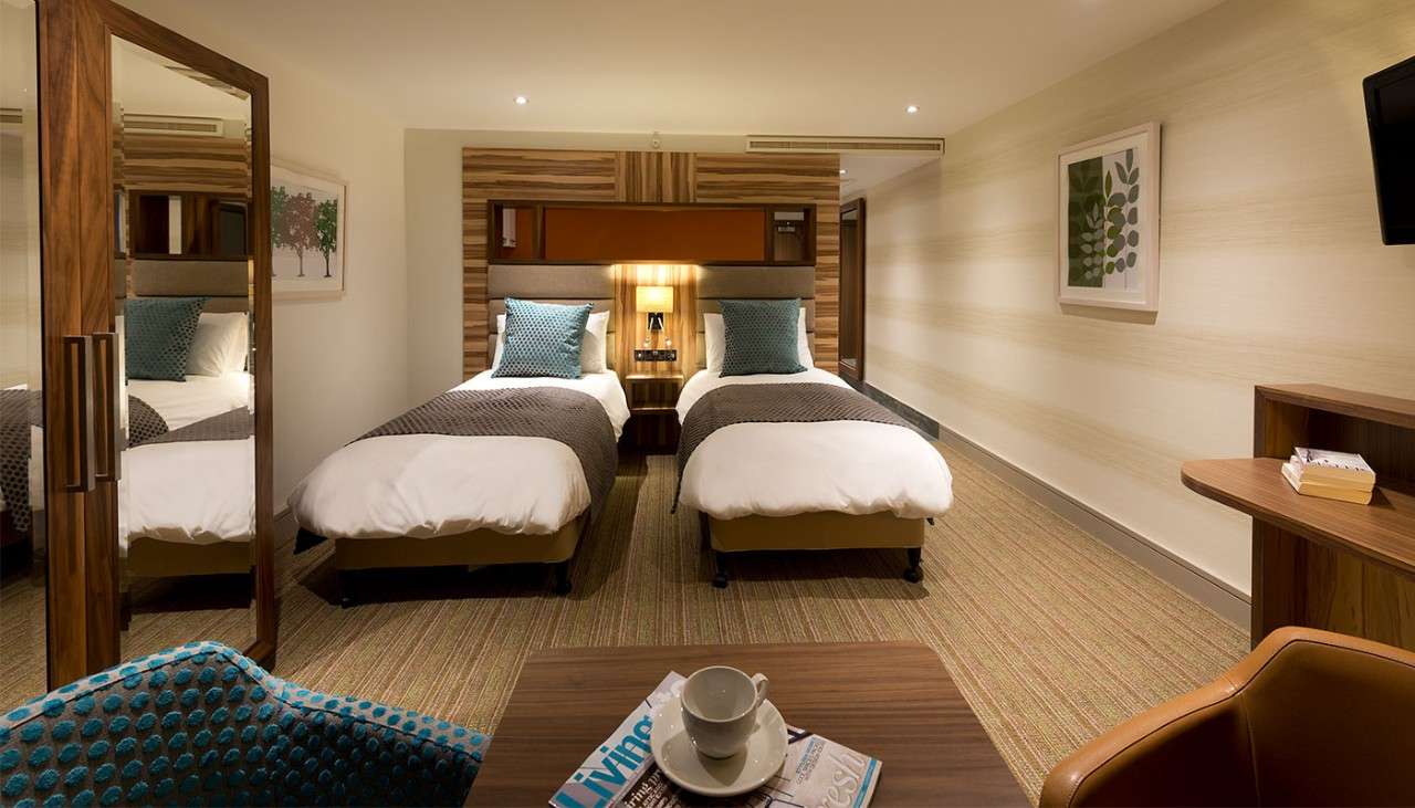 Neatly made twin beds in a hotel room available at Woburn and Elveden 