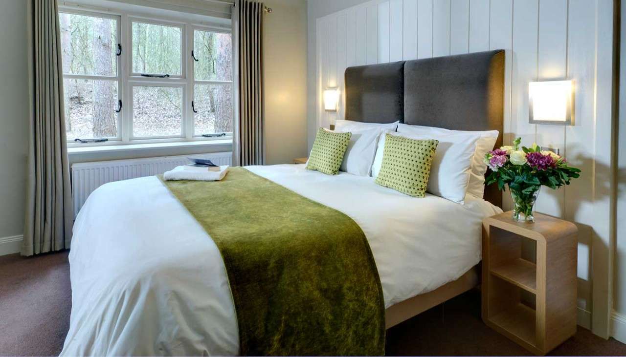 A neatly made double bed in an Exclusive Lodge 