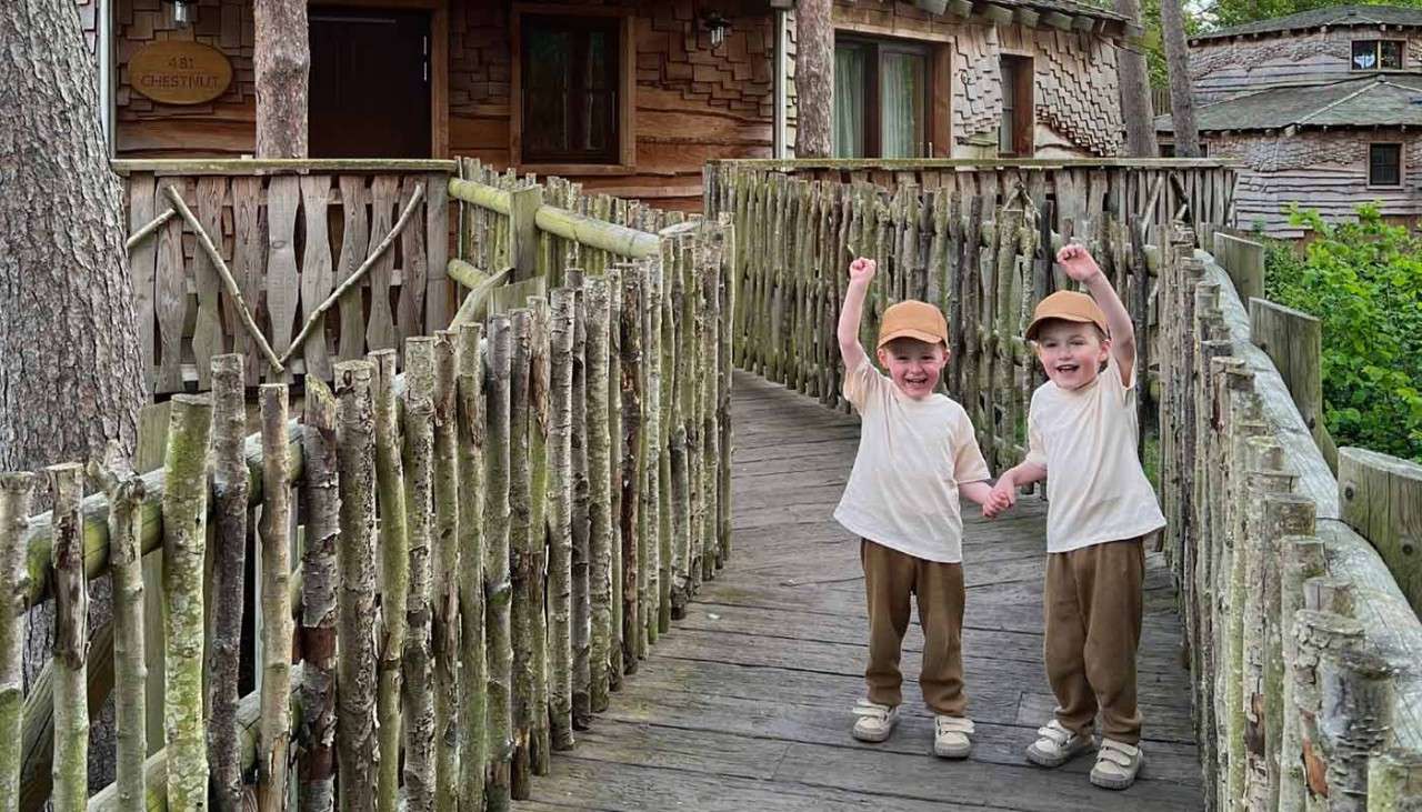 Two toddlers holding hands to the entrance of their Treehouse.